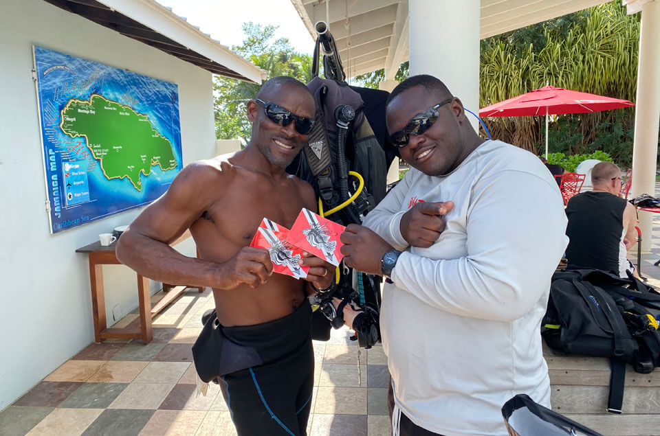 Divers holding Lionfish University stickers