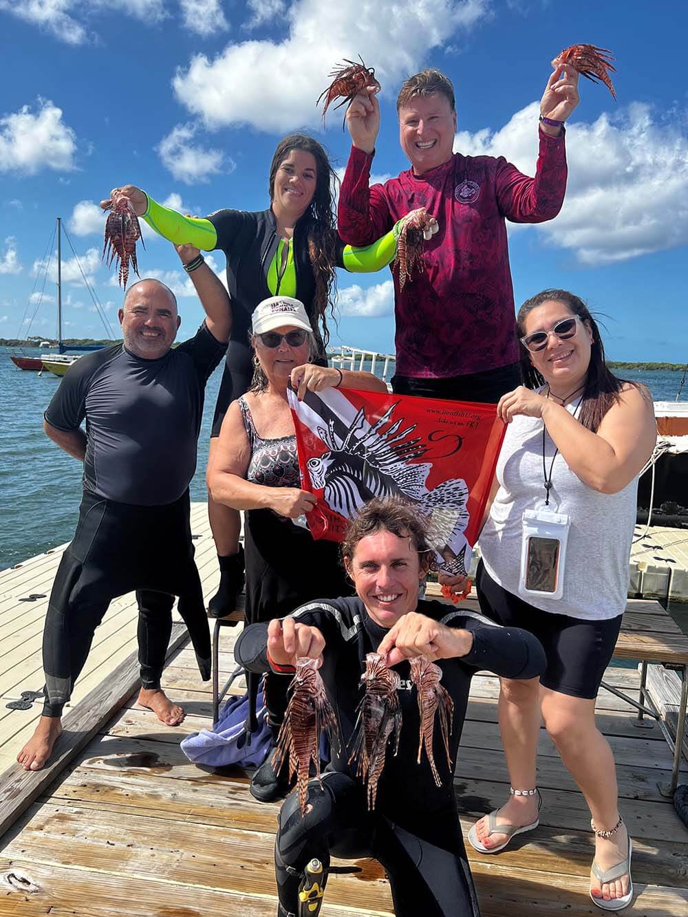 Group of divers holding lionfish in Aruba