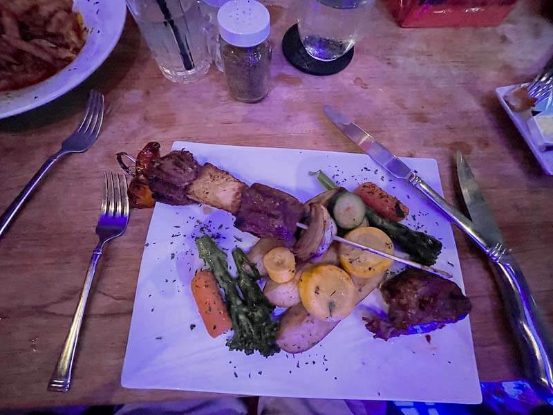 Skewerd meat and vegetables on dinner plate