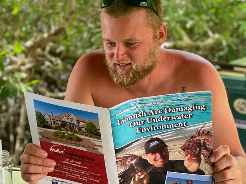 Aruba lionfish hunting friend reading a magazine