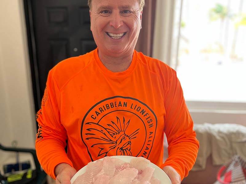 Roger J. Muller, Jr. holding plate of filleted lionfish