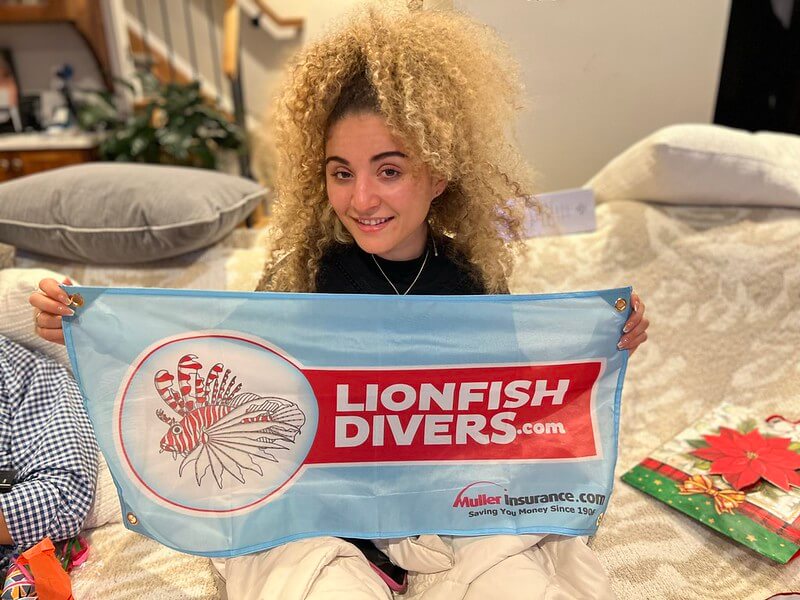 Taylor Muller holding Lionfish Divers flag