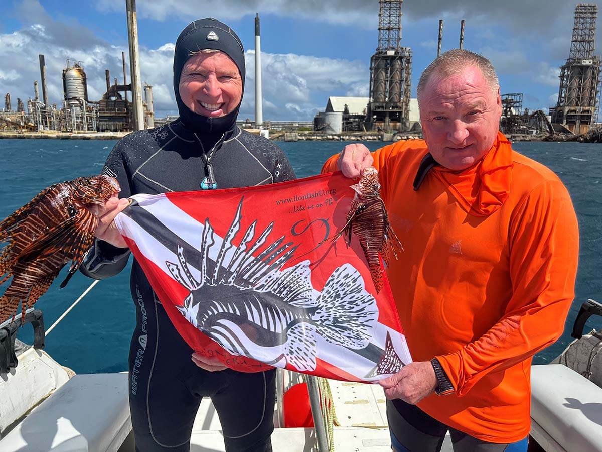 Perry Megens and Roger J. Muller, Jr. holding Lionfish University flag and lionfish