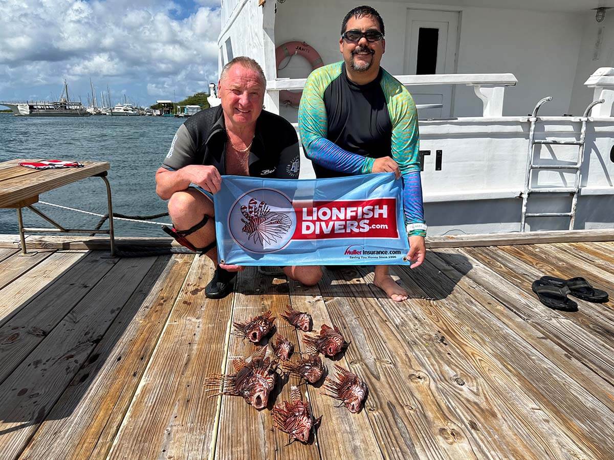 Perry Megens and Rafael Flores, Jr. Holding lionfishdivers.com flag and lionfish catch of the day