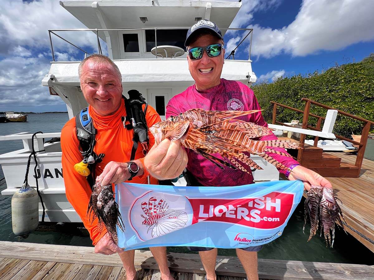 Perry Megens and Roger J. Muller, Jr. holding lionfishdivers.com flag and lionfish