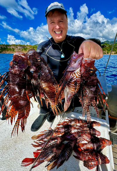 Roger Muller holding several lionfish speared in Aruba.