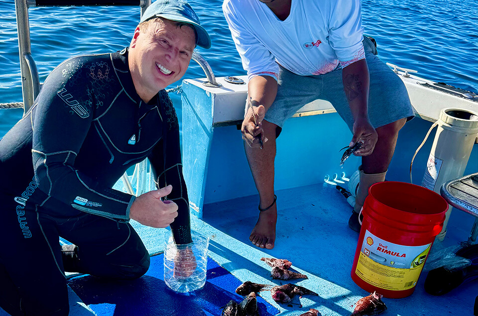 Roger Muller with hand in hot water to treat lionfish sting.
