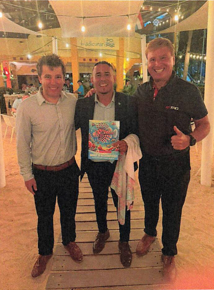 Presenting the "What is a Lionfish?" book at Hadicurari — Vasili Karalewich, Aruba Minister of Tourism Wendrick Cecilia, and Roger J. Muller Jr